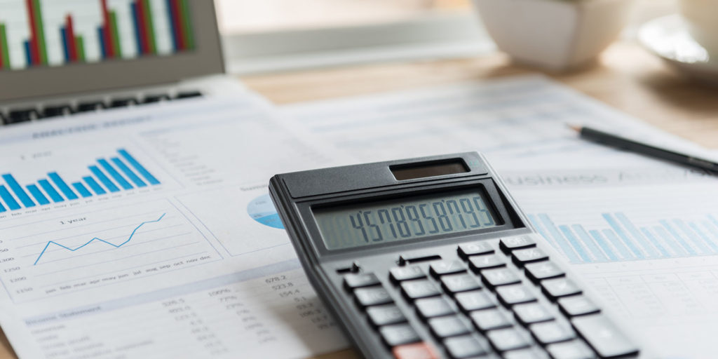 Accounting ledger on a desk with a calculator on top