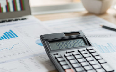 Accounting ledger on a desk with a calculator on top